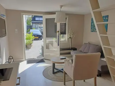 a living room with a couch and a table at Garden house, Free parking in Zandvoort