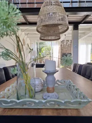 a dining room table with a candle and a chandelier at Rekerlanden 46 in Warmenhuizen