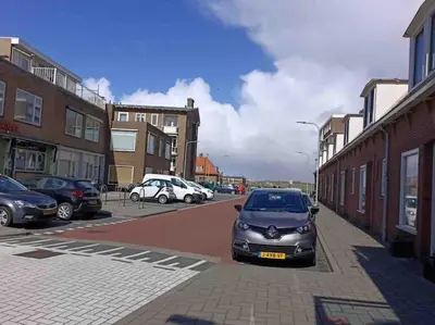 a small car parked on the side of a street at Schitterend appartement, 150 m van het strand in Katwijk aan Zee