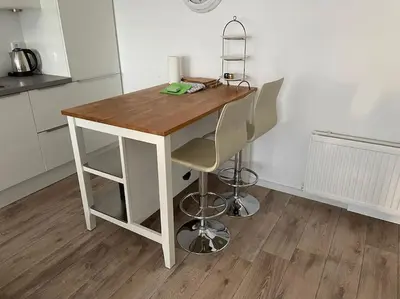 a wooden table with two chairs in a kitchen at Schitterend appartement, 150 m van het strand in Katwijk aan Zee