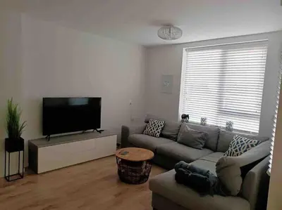 a living room with a couch and a flat screen tv at Schitterend appartement, 150 m van het strand in Katwijk aan Zee