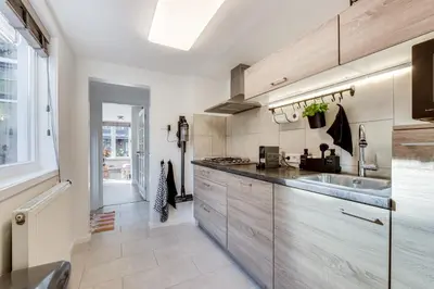 a kitchen with wooden cabinets and a sink at Dorpsgeluk centrum Uitgeest in Uitgeest
