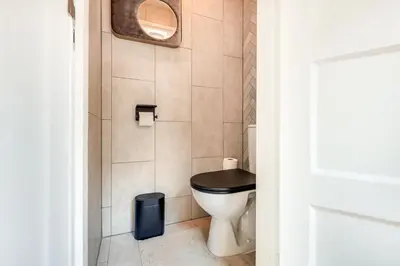 a bathroom with a toilet with a black seat at Dorpsgeluk centrum Uitgeest in Uitgeest