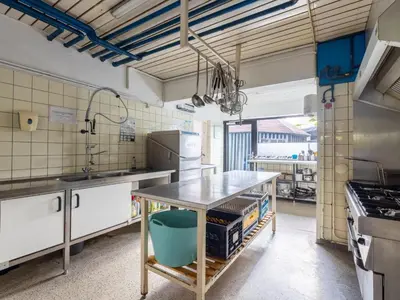 a kitchen with a table in the middle of it at De Kaag Watersport Groepsaccommodatie - 80 pers in Kaag