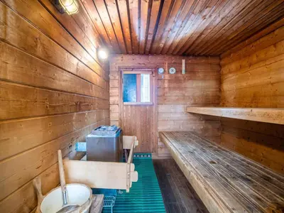 an empty wooden room with benches in a cabin at De Kaag Watersport Groepsaccommodatie - 80 pers in Kaag
