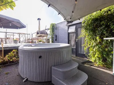 a jacuzzi tub sitting on top of a patio at De Kaag Watersport Groepsaccommodatie - 80 pers in Kaag