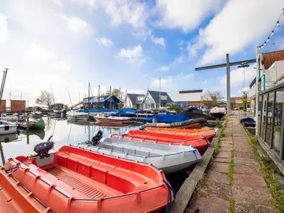 a group of boats are docked in a harbor at De Kaag Watersport Groepsaccommodatie - 80 pers in Kaag