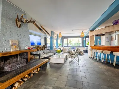 a living room with a couch and a fireplace at De Kaag Watersport Groepsaccommodatie - 80 pers in Kaag