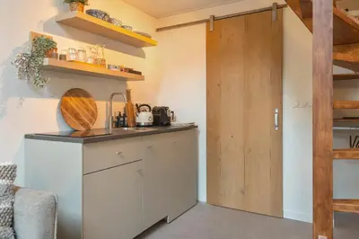 a kitchen with a counter and a wooden door at The Green Pine Tree in Zandvoort