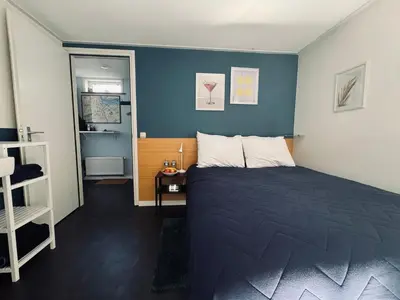a bedroom with a bed and a blue wall at Peaceful room on a houseboat in the city centre in Amsterdam