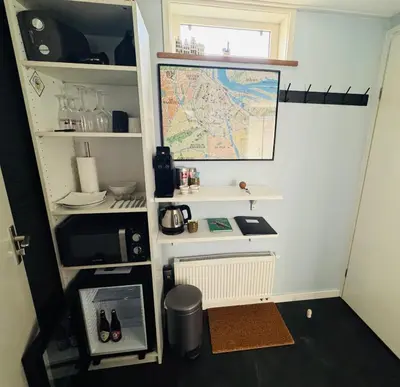 a small room with a desk and a map on the wall at Peaceful room on a houseboat in the city centre in Amsterdam