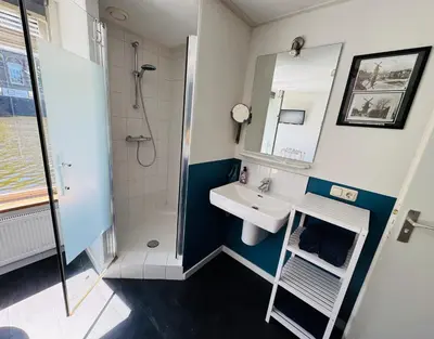a small bathroom with a sink and a shower at Peaceful room on a houseboat in the city centre in Amsterdam