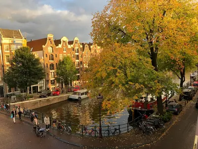 a group of people walking along a river in a city at Décor Canal House in Amsterdam