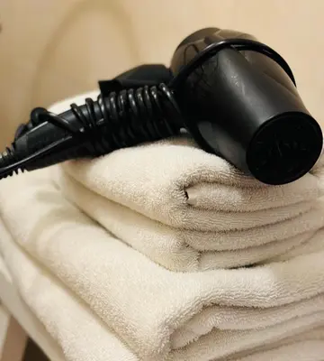 a black hairdryer sitting on top of towels at Décor Canal House in Amsterdam