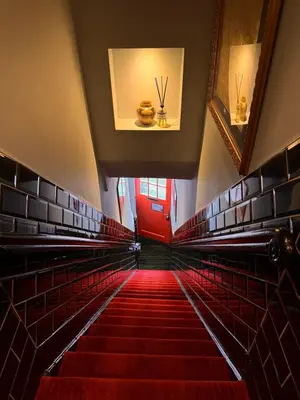 a staircase in a building with a red door and red carpet at Décor Canal House in Amsterdam
