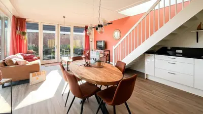 a living room with a wooden table and chairs at Havenzicht by Droomvilla in Uitgeest