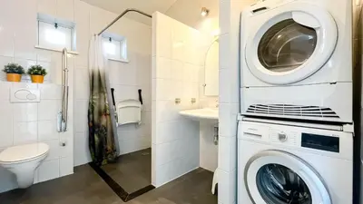 a washer and dryer in a bathroom with a sink at Droomzicht by Droomvilla in Uitgeest