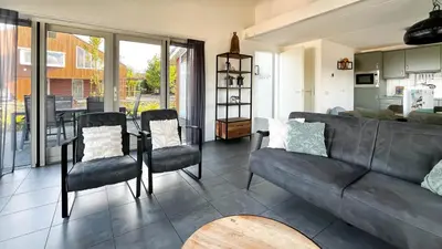 a living room with a leather couch and chairs at Droomzicht by Droomvilla in Uitgeest