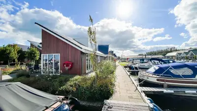 a marina with boats parked next to a building at Droomzicht by Droomvilla in Uitgeest