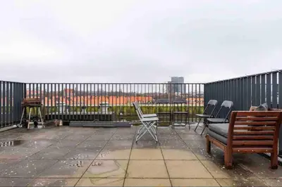 a patio with chairs and a table and a fence at 120m2 Spacious 4-bedroom Apartment with Roofterras in Amsterdam