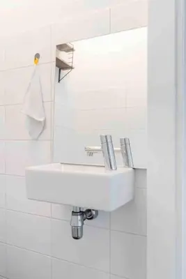 a bathroom with a white sink and a mirror at 120m2 Spacious 4-bedroom Apartment with Roofterras in Amsterdam