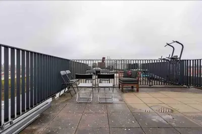 a patio with chairs and tables on a balcony at 120m2 Spacious 4-bedroom Apartment with Roofterras in Amsterdam