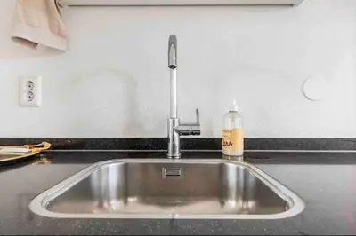 a kitchen sink with a soap bottle on a counter at 120m2 Spacious 4-bedroom Apartment with Roofterras in Amsterdam