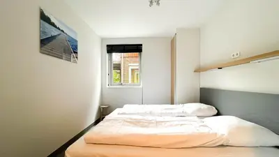 a bedroom with two beds and a window at Schelpzicht by Droomvilla in Uitgeest