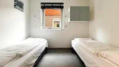 two beds in a room with a window at Schelpzicht by Droomvilla in Uitgeest