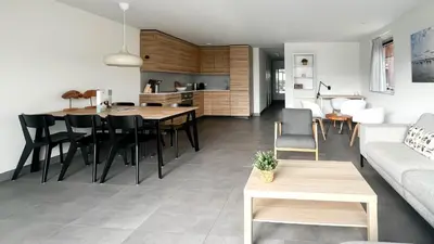 a living room and kitchen with a table and a couch at Schelpzicht by Droomvilla in Uitgeest