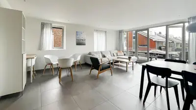 a living room with a couch and a table and chairs at Schelpzicht by Droomvilla in Uitgeest