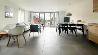 a living room with a couch and tables and chairs at Schelpzicht by Droomvilla in Uitgeest