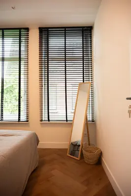 a bedroom with a easel and a bed and windows at PURMERENT Apartments in Purmerend