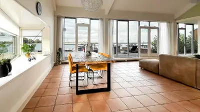 a living room with a table and a couch at Sterrenzicht by Droomvilla in Uitgeest