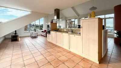 a large kitchen with a counter and a large window at Sterrenzicht by Droomvilla in Uitgeest