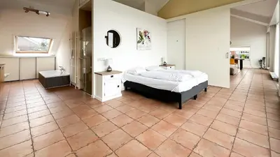 a bedroom with a bed and a tub and a sink at Sterrenzicht by Droomvilla in Uitgeest