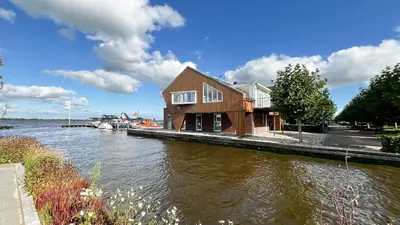 a house on a dock next to a body of water at Sterrenzicht by Droomvilla in Uitgeest