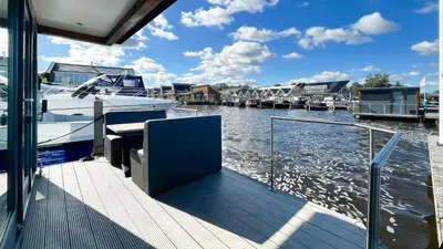 a dock with a boat on the water at Golfzicht by Droomvilla in Uitgeest