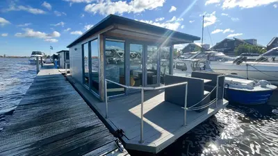 a small boat is docked at a dock at Golfzicht by Droomvilla in Uitgeest