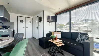 a living room with a blue couch and a table at Golfzicht by Droomvilla in Uitgeest