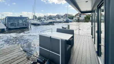 a dock with boats docked in the water at Prachtzicht by Droomvilla in Uitgeest