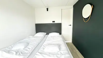 a small bedroom with three beds in it at Prachtzicht by Droomvilla in Uitgeest