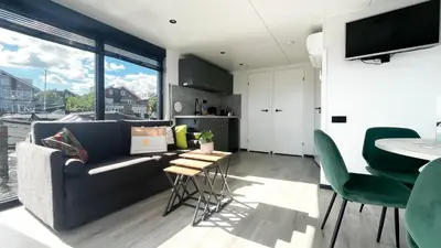 a living room with a couch and a table at Prachtzicht by Droomvilla in Uitgeest