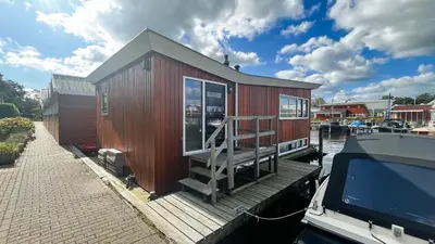 a small house on a boat in a marina at Jachtzicht by Droomvilla in Uitgeest