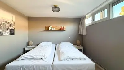 two beds in a room with two windows at Jachtzicht by Droomvilla in Uitgeest