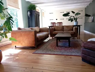 a living room with two couches and a table at Bedstee in de polder in Egmond aan den Hoef