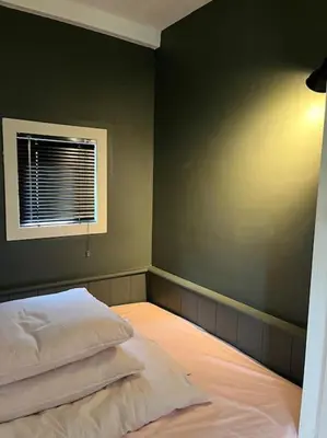 an empty bedroom with a bed and a window at Bedstee in de polder in Egmond aan den Hoef