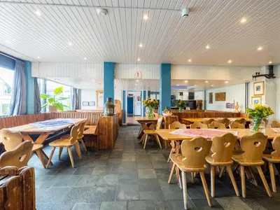 a dining room with wooden tables and chairs at De Kaag Watersport Groepsaccommodatie - 30 pers in Kaag