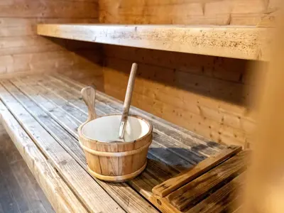 a bucket and two wooden spoons sitting on a shelf in a sauna at De Kaag Watersport Groepsaccommodatie - 30 pers in Kaag