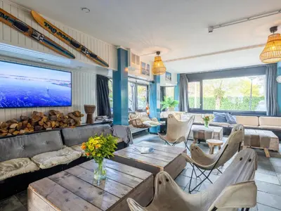 a living room with a couch and a table at De Kaag Watersport Groepsaccommodatie - 30 pers in Kaag